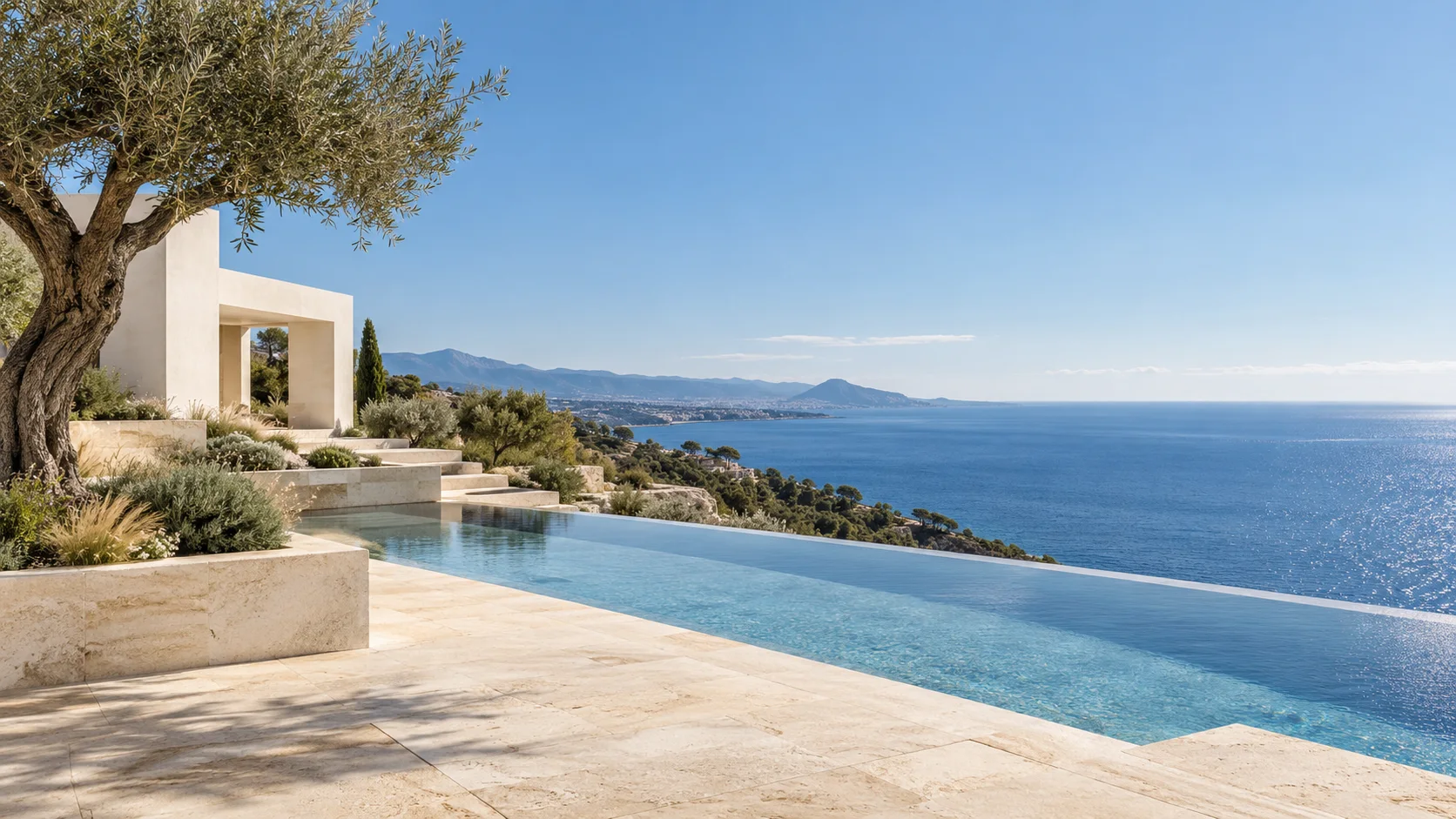 Sunlit limestone terrace and infinity pool overlooking the Mediterranean sea